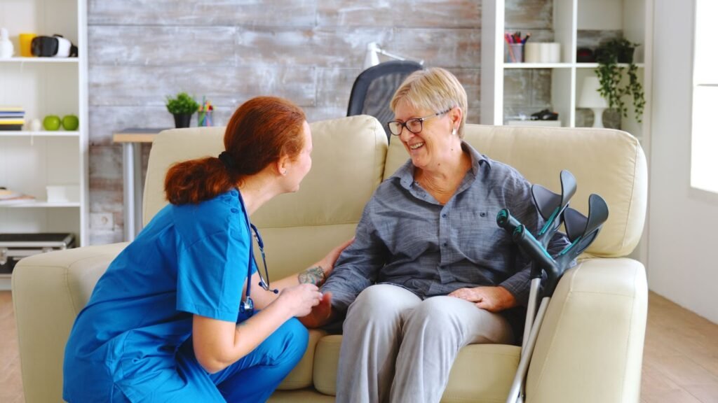 A nurse talking with old woman with sitting on a couch 